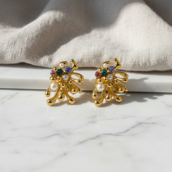 elephantina.gr gold-tone abstract earrings with small pearls and colorful crystals on a marble surface