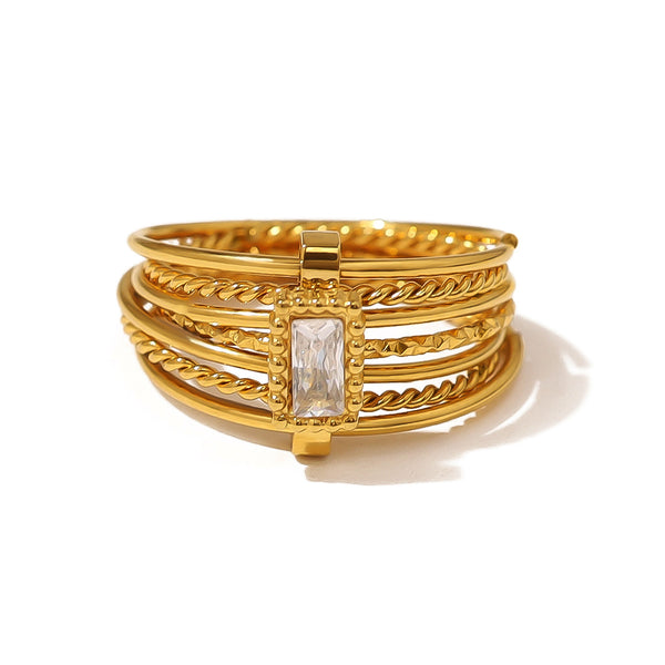 Επιχρυσωμένο ατσάλινο δαχτυλίδι με πλεκτές λεπτομέρειες και πέτρα baguette