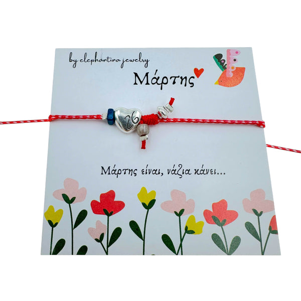 Μαρτάκι Βραχιόλι με Καρδιά & Μπλε Πέτρα – Ασημί Στοιχεία σε Κόκκινη-Λευκή Κλωστή