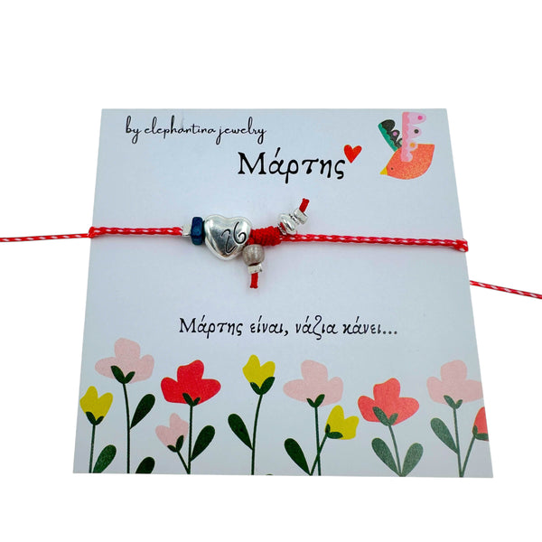 Μαρτάκι Βραχιόλι με Καρδιά & Μπλε Πέτρα – Ασημί Στοιχεία σε Κόκκινη-Λευκή Κλωστή