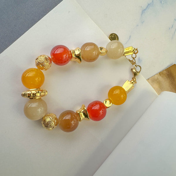Χειροποίητο βραχιόλι με γυάλινες χάντρες σε ζεστές αποχρώσεις και χρυσά στοιχεία