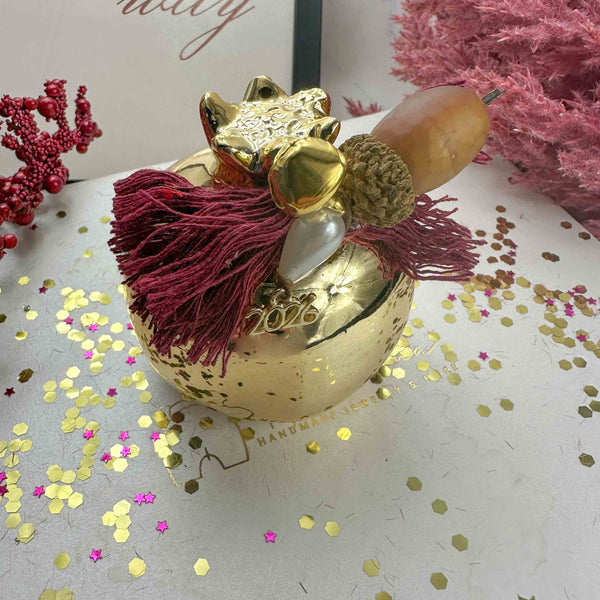 Κεραμικό Χρυσό Ρόδι Διακοσμητικό – Γούρι 2026 με Μπορντό Βαμβακερές Κλωστές (7×7cm)