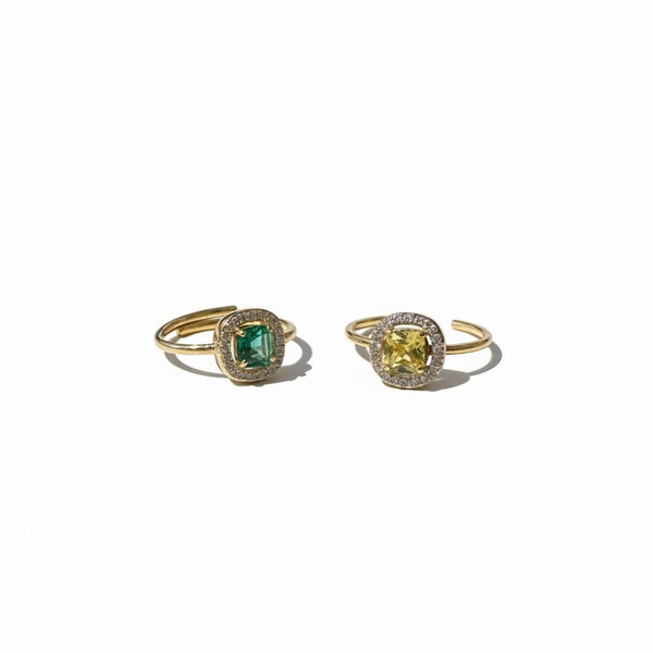 elephantina.gr adjustable gold-tone rings with cushion-cut emerald green and yellow stones and pavé crystal halos.