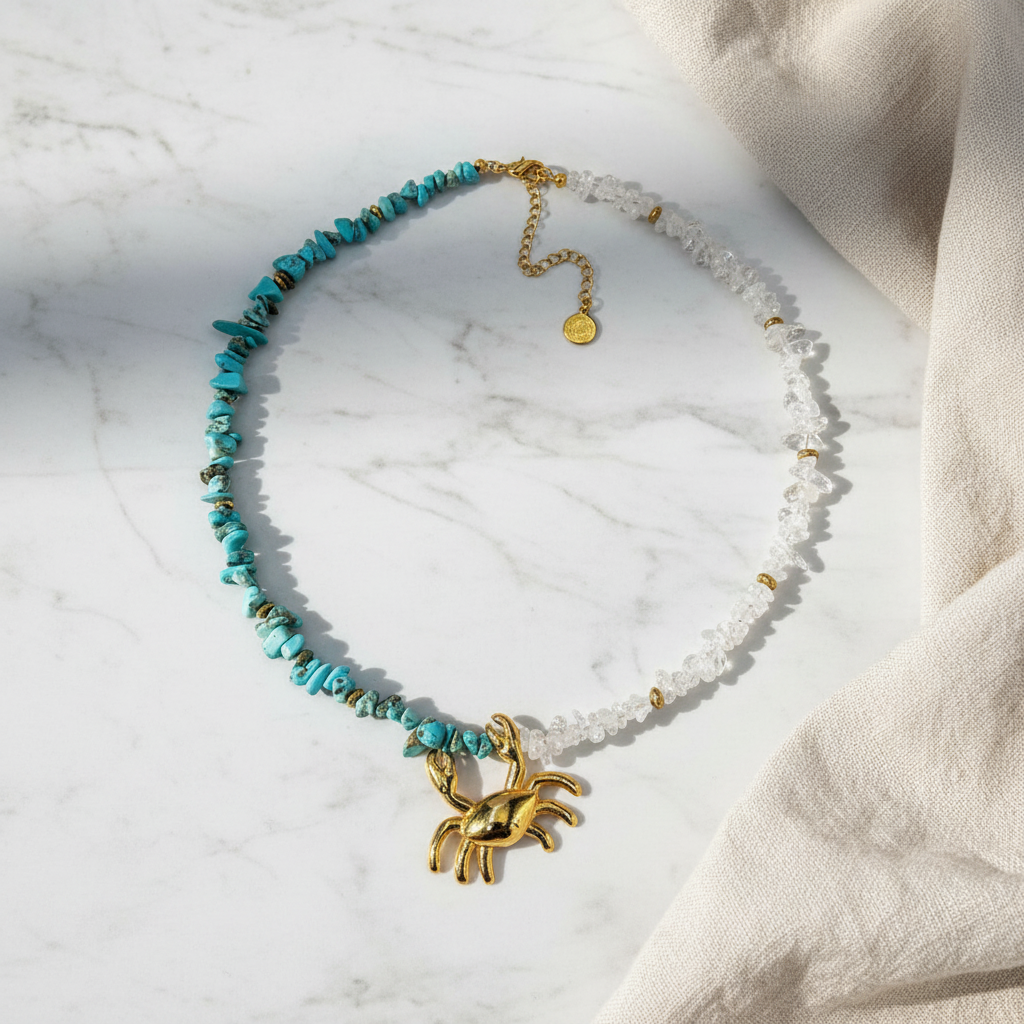 elephantina.gr necklace featuring a gold crab pendant with turquoise howlite and clear quartz crystal beads