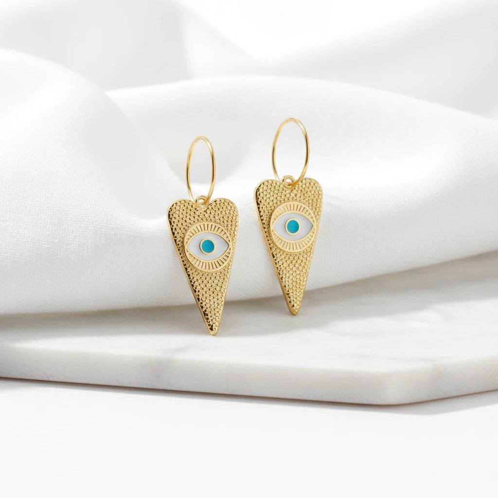 elephantina.gr 24K gold-plated brass hoop earrings featuring heart-shaped charms with a turquoise evil eye motif.