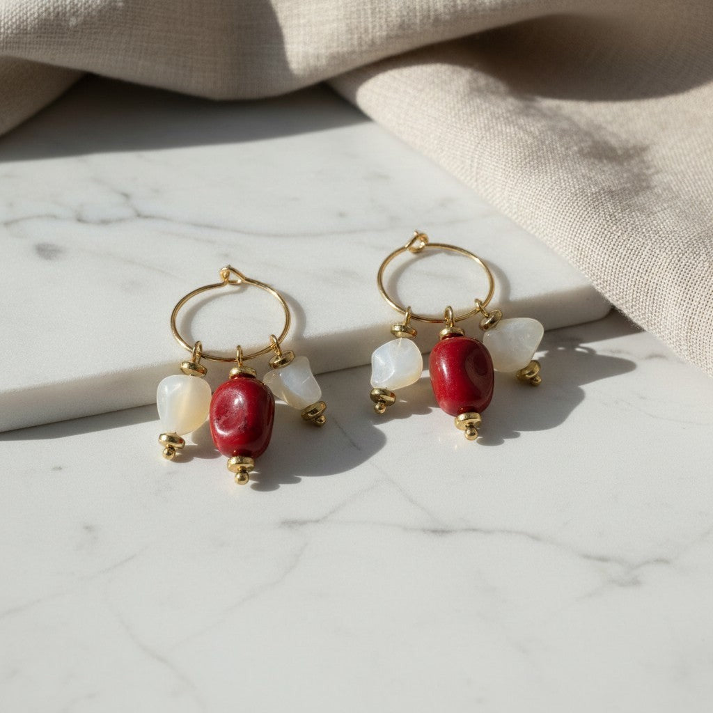 elephantina.gr gold hoop earrings featuring red and white natural stone beads on a marble surface