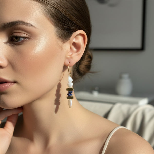elephantina.gr gold hoop earrings featuring white pearls and blue lapis lazuli beads worn by a woman