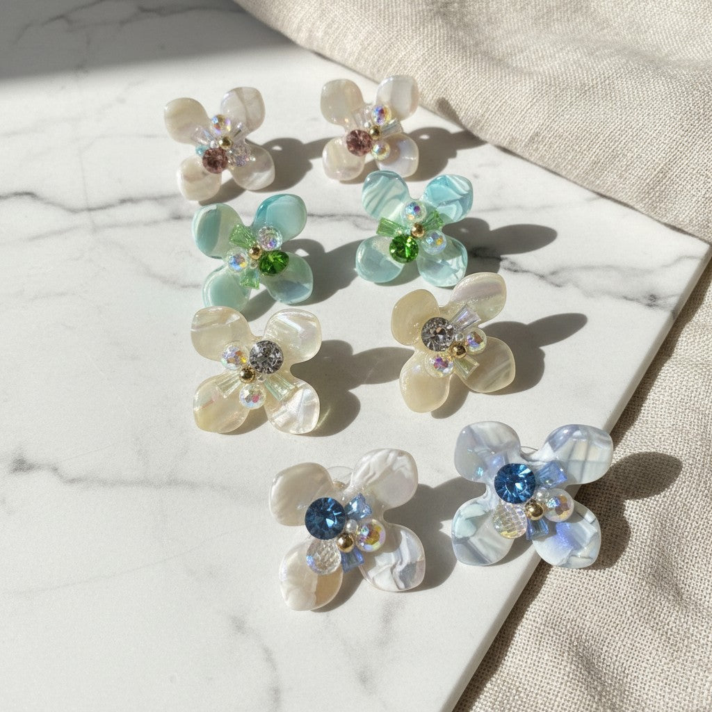 elephantina.gr flower earrings with iridescent petals and colorful crystal centers on a marble surface