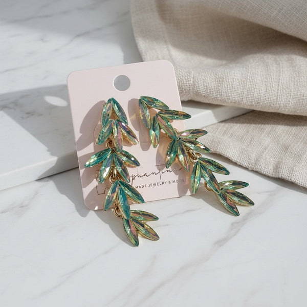 elephantina.gr long leaf-shaped earrings with iridescent green crystals on a light pink display card