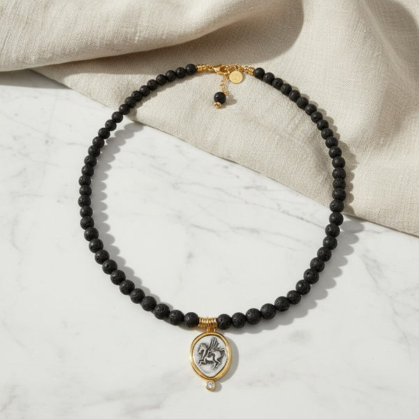 elephantina.gr black lava bead necklace with a gold-framed Pegasus pendant and a small sparkling crystal accent