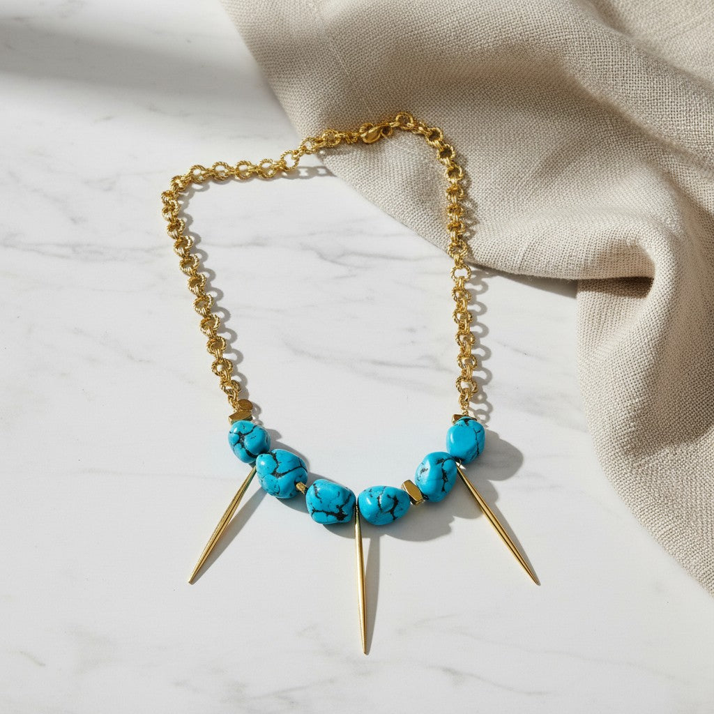 elephantina.gr necklace featuring bright blue turquoise stones and gold-tone metal spikes on a chunky chain