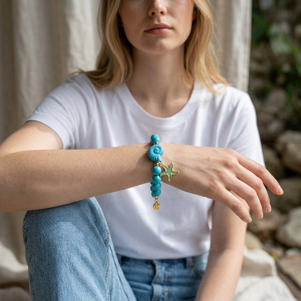 elephantina.gr turquoise beaded bracelet with a starfish charm worn on a woman's wrist