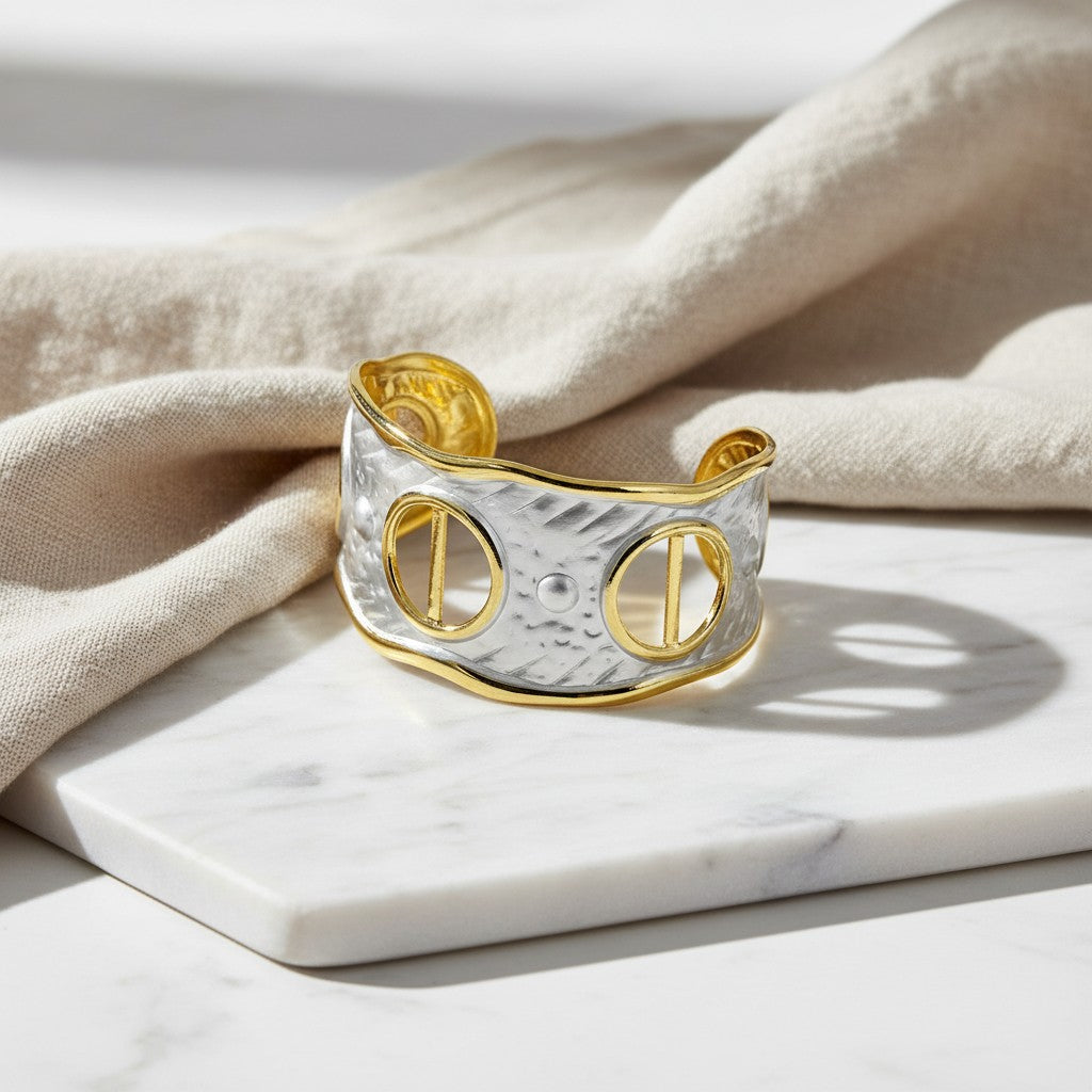 Χειροποίητο βραχιόλι cuff elephantina.gr σε ασημί και χρυσό χρώμα με ανάγλυφη υφή και γεωμετρικά ανοίγματα.