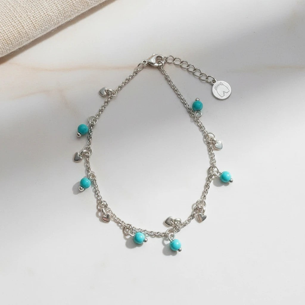 Silver anklet with heart charms and turquoise beads, made of stainless steel. Adjustable length.