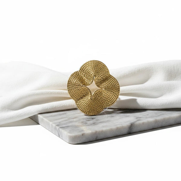 elephantina.gr gold-tone statement cuff bracelet with a sculptural, textured floral motif on a marble base.