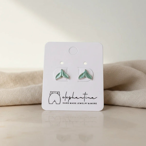elephantina.gr whale tail stud earrings with seafoam green enamel accents and brushed silver-tone finish.