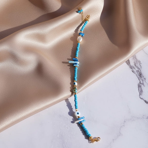 Elephantina.gr blue beaded anklet with coral, evil eye, pearl, and turquoise beads. Adjustable length.