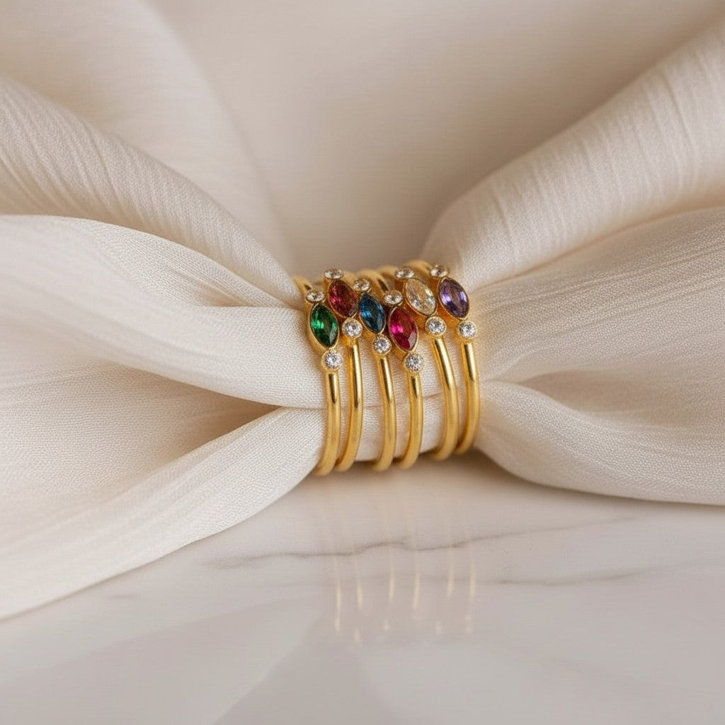 Stack of elephantina.gr gold-plated steel rings with colorful marquise-cut crystals and white zircons.