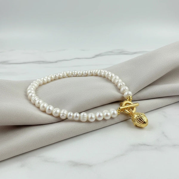 elephantina.gr pearl necklace with gold T-bar clasp and acorn charm. 45cm length.