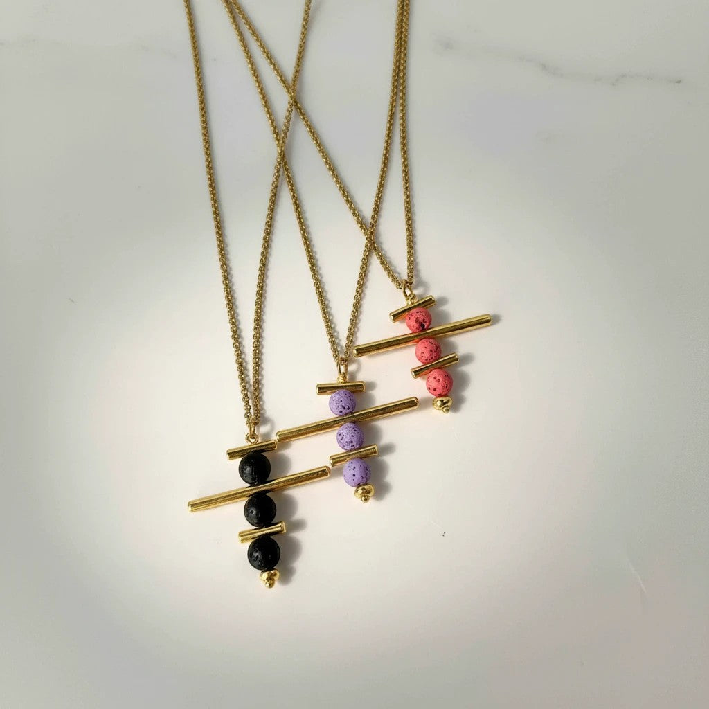 Elephantina.gr gold-plated brass necklace with colorful lava beads and geometric elements. Available in black, purple, and pink.