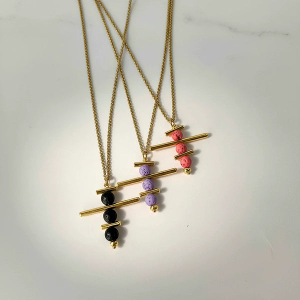 Elephantina.gr gold-plated brass necklace with colorful lava beads and geometric elements. Available in black, purple, and pink.