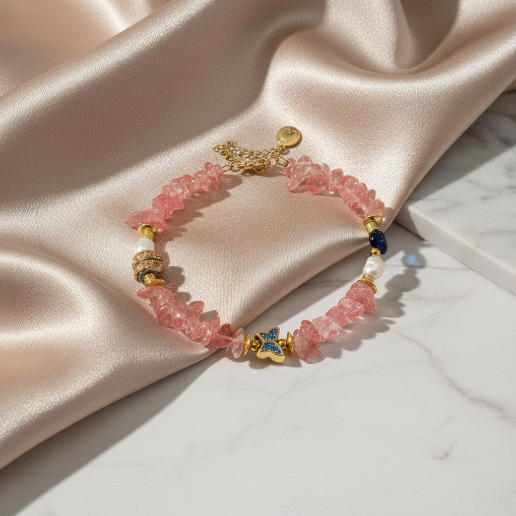 elephantina.gr anklet with pink stones, pearls, and a gold butterfly charm with blue accents.