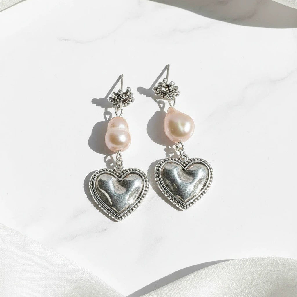 elephantina.gr silver-plated brass stud earrings with baroque pearls and heart charms featuring an evil eye design.