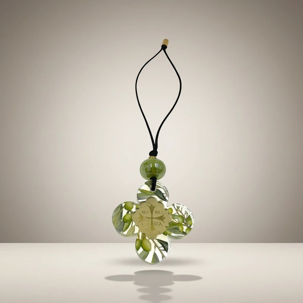 Clear acrylic cross ornament with olive branch design, gold emblem, and green bead. elephantina.gr