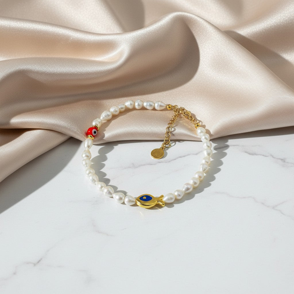 Elephantina.gr pearl anklet with gold fish charm and red evil eye bead. Adjustable length.