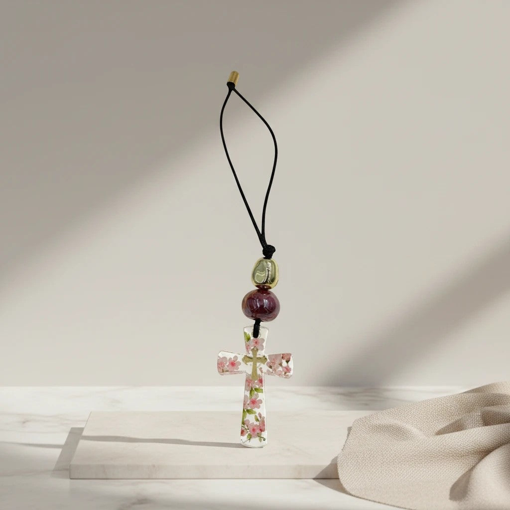 Clear resin cross ornament with pink flowers, burgundy bead, gold bead, and black cord by elephantina.gr.