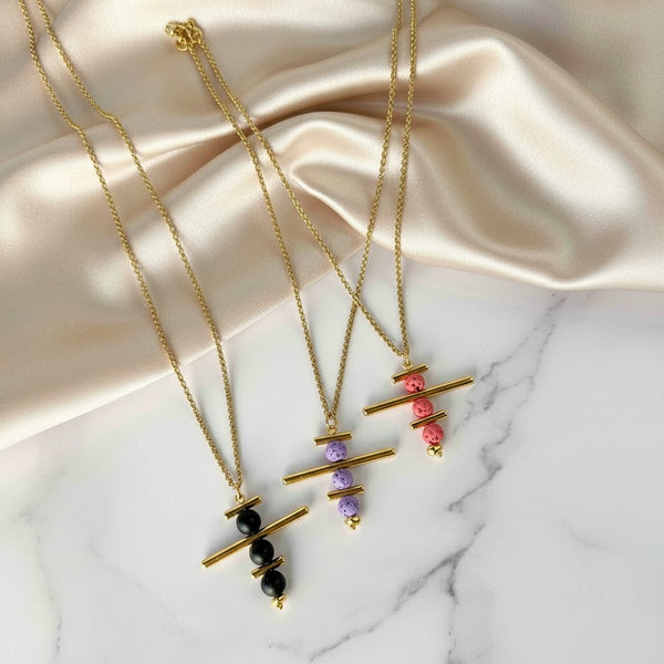 Elephantina.gr gold plated brass geometric necklace with colorful lava beads in black, purple, and pink.