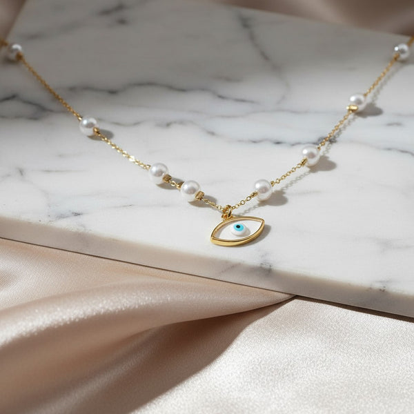 Gold stainless steel necklace with pearls and a white evil eye charm from elephantina.gr