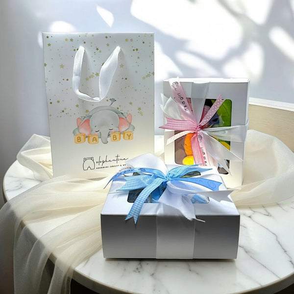 elephantina.gr gift packaging with a baby elephant design, includes a gift bag, a white box with blue ribbon, and a white box with pink ribbon.