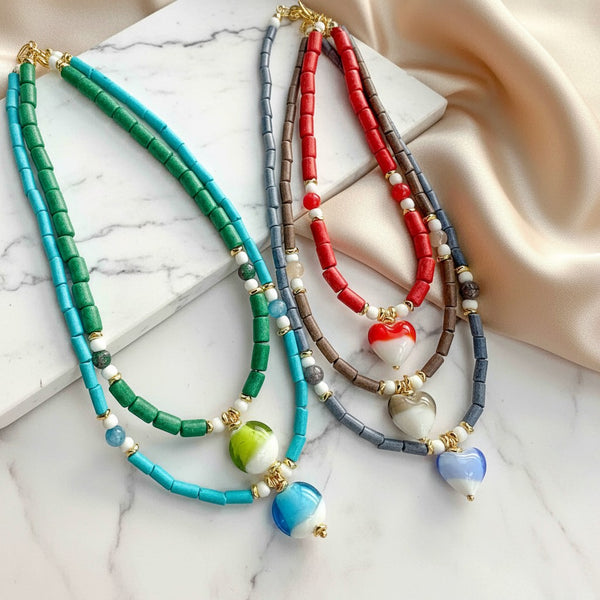 Elephantina.gr handmade necklaces with Murano glass hearts and beads in turquoise, green, red, grey, and brown.