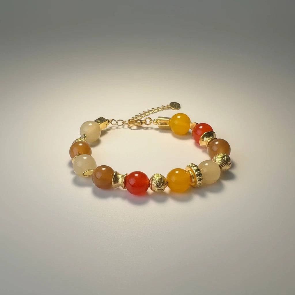 Handmade elephantina.gr bracelet with glass beads in warm orange, honey, and sand tones, accented with gold elements. Features an adjustable clasp.