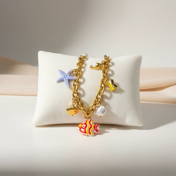 Gold chain bracelet with colorful charms: red and yellow fish, pearl, starfish, and shell. Elephantina.gr