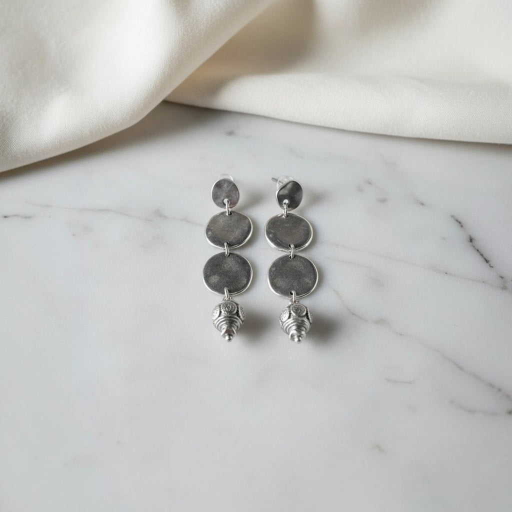 elephantina.gr silver-tone drop earrings with three hammered discs and a detailed bead charm.