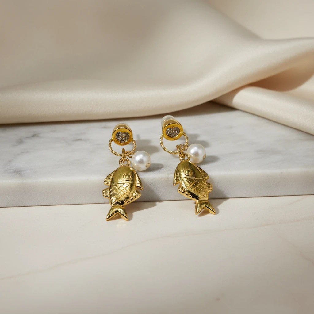 elephantina.gr gold-tone fish dangle earrings with faux pearls and glittery heart tops.