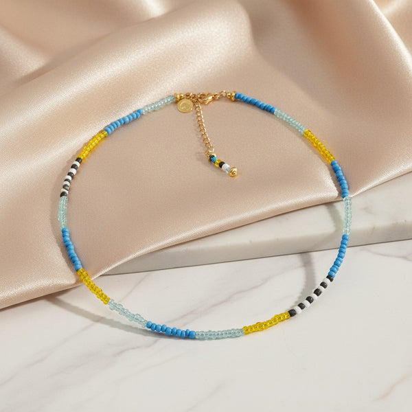 Elephantina.gr handmade beaded necklace with blue, yellow, and grey beads. Summer design with adjustable gold clasp.