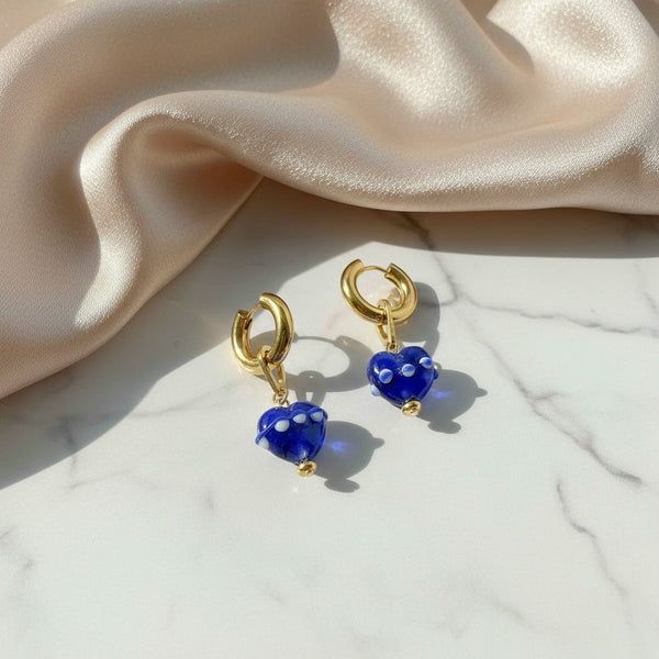 elephantina.gr gold hoop earrings with blue ceramic heart charms featuring white details on a marble surface
