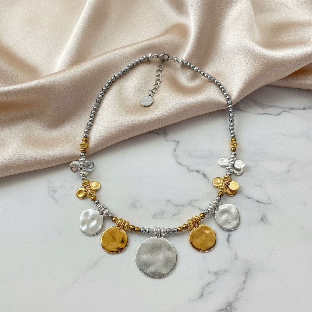 elephantina.gr silver necklace with beads, gold and silver disc charms, and butterfly accents. Modern chic design.