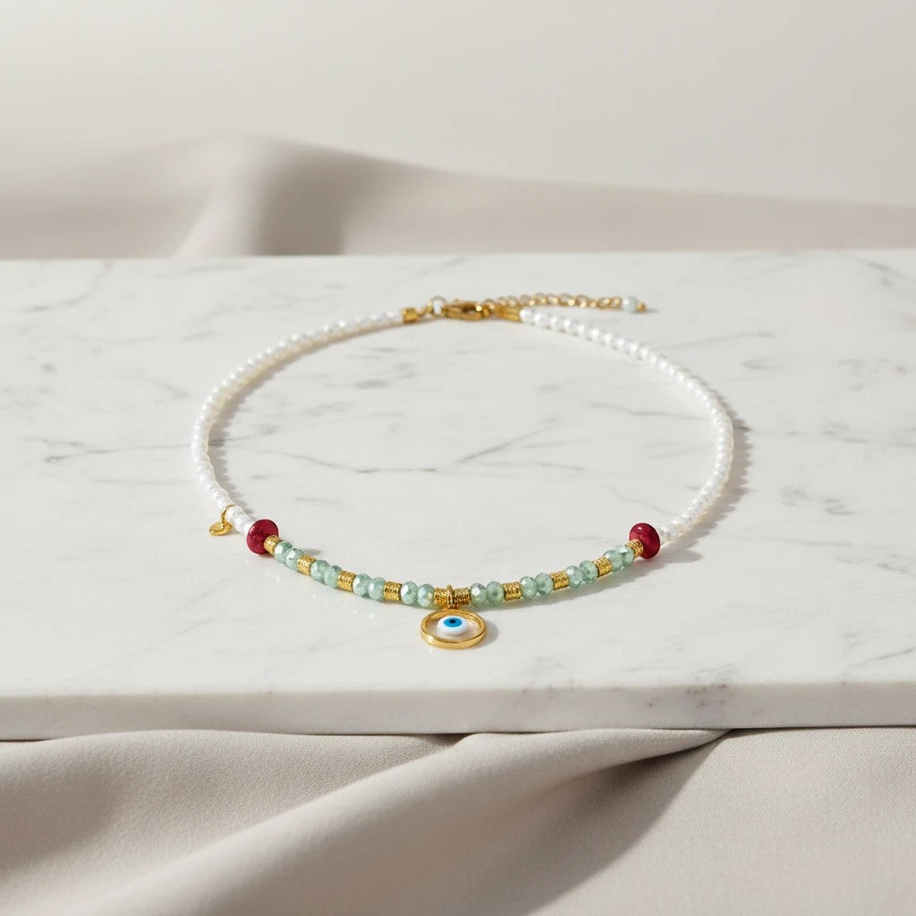 elephantina.gr white freshwater pearl necklace with green crystals, red beads, and evil eye charm.