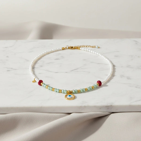 elephantina.gr white freshwater pearl necklace with green crystals, red beads, and evil eye charm.
