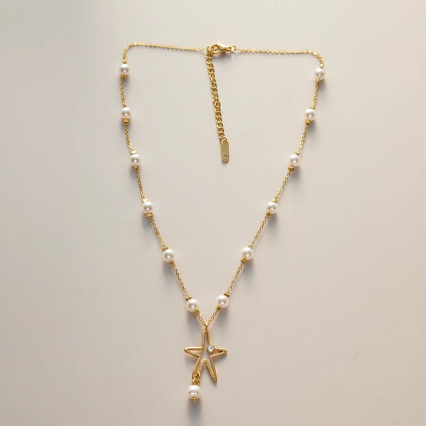 Gold stainless steel necklace with white pearls and a star pendant with a pearl drop. Adjustable chain.