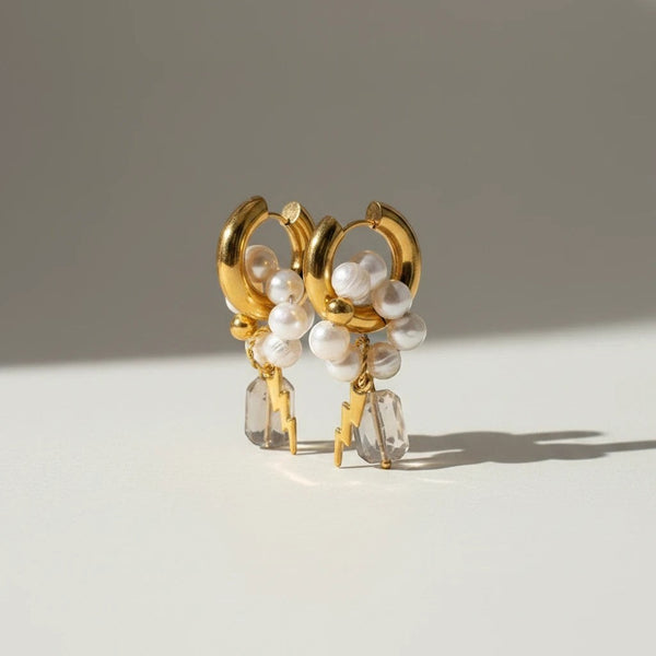 Elephantina handmade gold-tone hoop earrings with freshwater pearls, clear crystals, and lightning bolt charms.