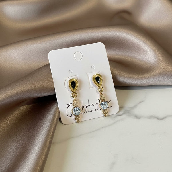 Elegant elephantina.gr gold-tone dangle earrings with black teardrop stones and clear cubic zirconia accents.