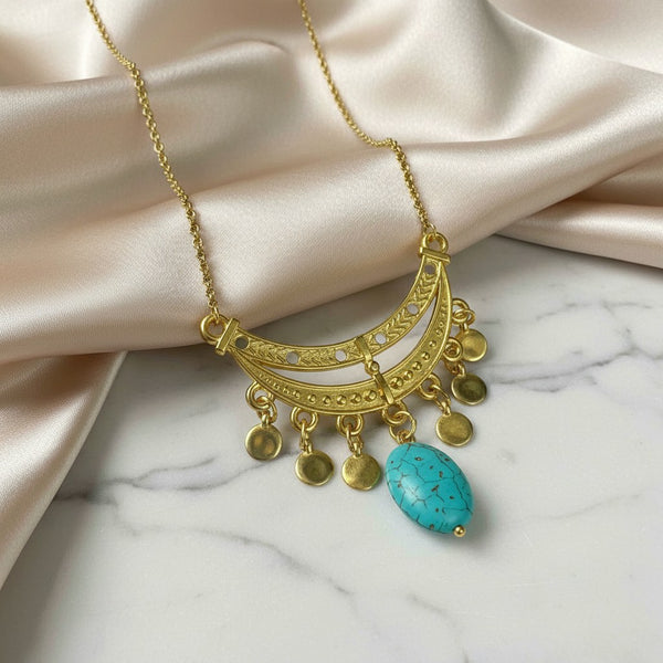 Elephantina.gr gold-plated brass necklace with turquoise stone and dangling charms. Features intricate detailing and a crescent moon design.