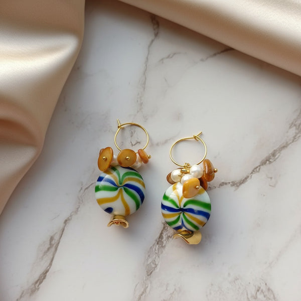 elephantina.gr multiball hoop earrings with Murano glass, pearls, and semi-precious stones on a marble background.
