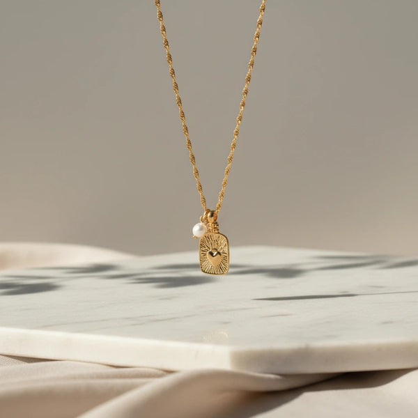 Gold plated stainless steel necklace with a heart-shaped ID tag and a pearl accent. elephantina.gr