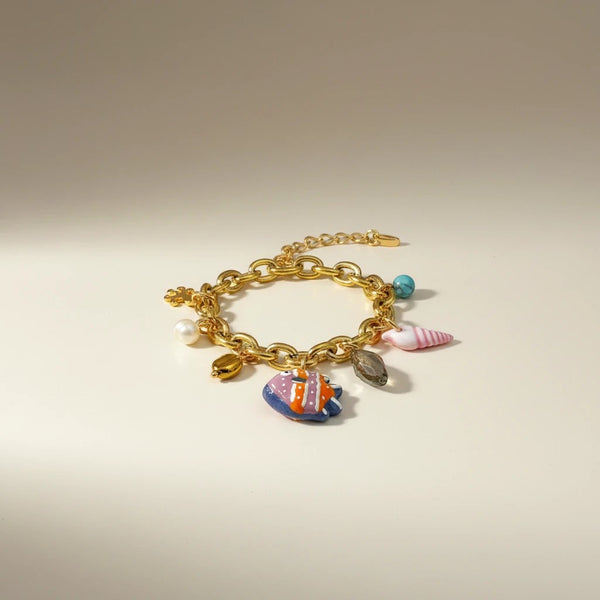 Gold chain bracelet with colorful charms: Murano glass fish, pearl, turquoise, shell, and hematite. Elephantina.gr boho summer jewelry.